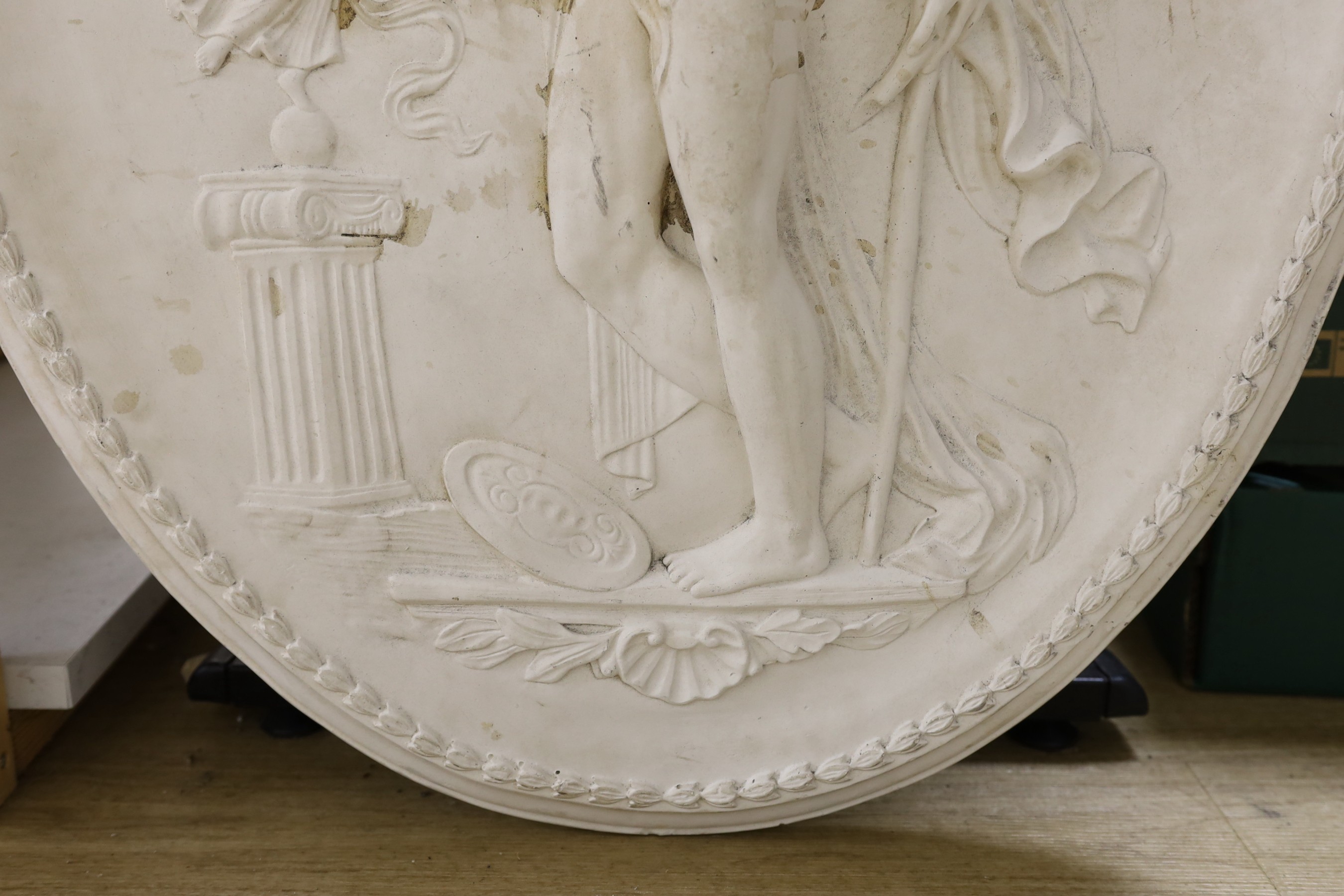 A cast plaster oval figural plaque, 84 cms high